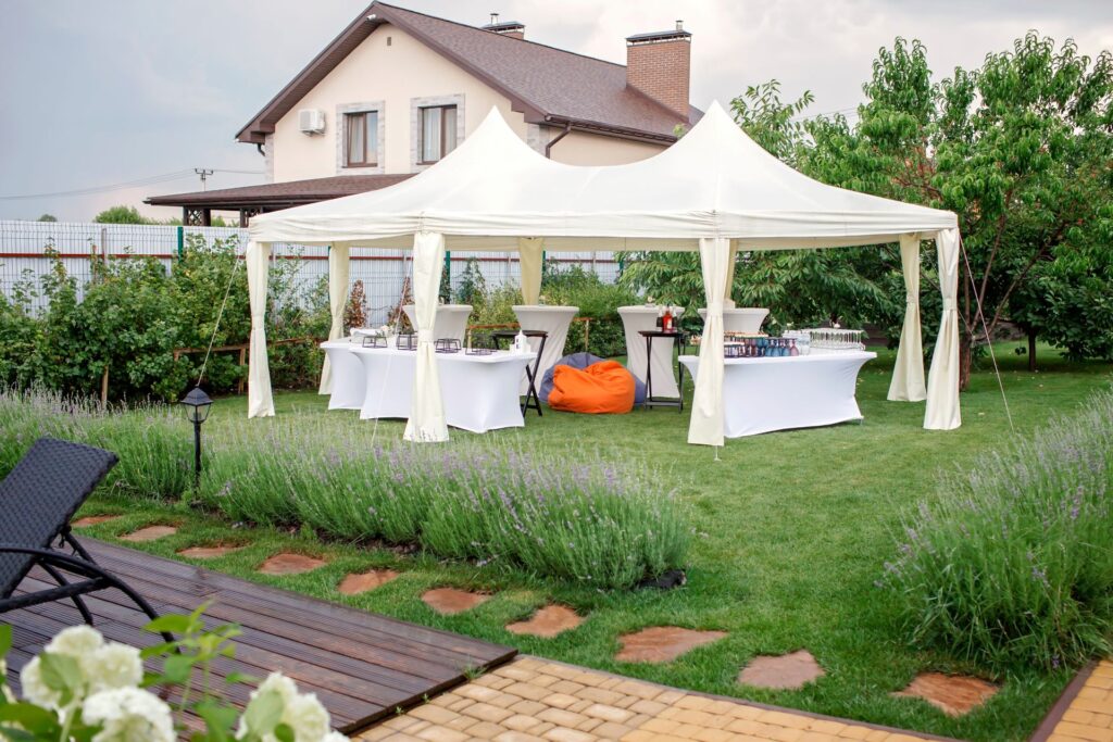 Pavillon mit Buffet, Stehtischen und Getraenken im gepflegten Garten eines Wohnhauses